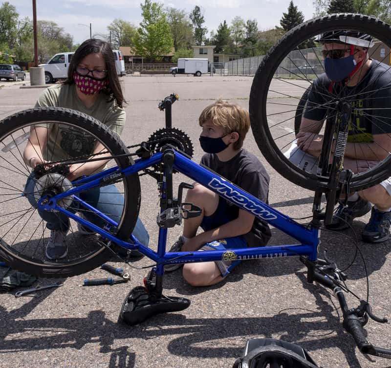 A child learns to repair a bicycle