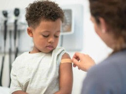 Doctor putting bandaid on child