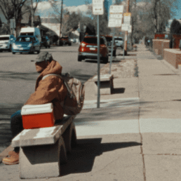Man sitting on bench waiting for bus